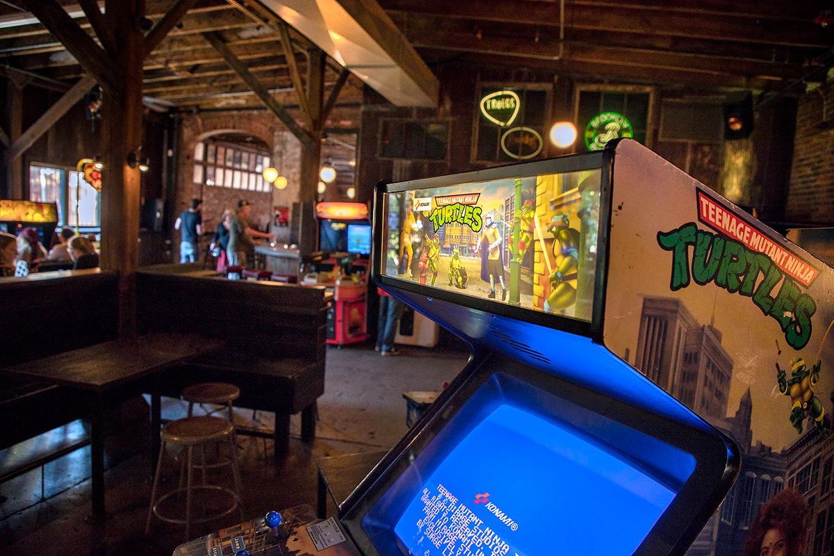 Bar with arcade games and tables and seating
